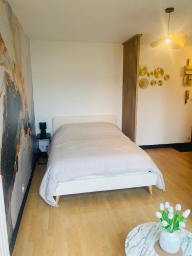 a bedroom with a white bed and a table at Charmant Studio in Vitré