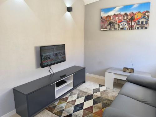 a living room with a tv and a couch at Beach house for 4 by the sea in Gafanha da Nazaré