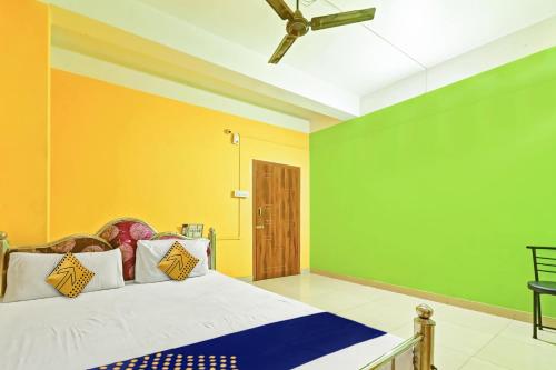 a bedroom with a bed with yellow and green walls at Hotel O Homely Residency in Guwahati