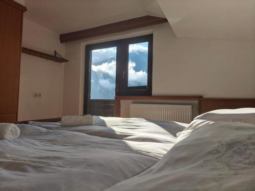 a bedroom with two beds in front of a window at Sport Apartments Tirol in Umhausen