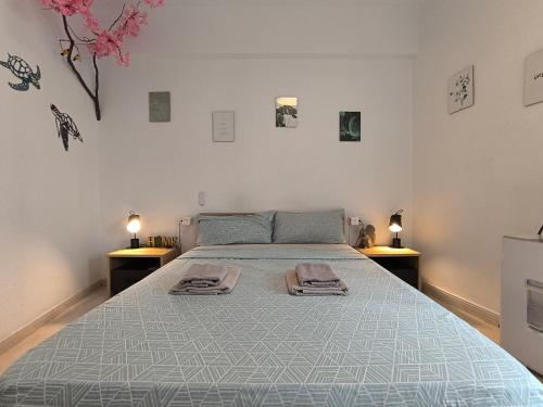 une chambre avec un grand lit avec deux tables de nuit dans l'établissement GUESTHOUSE SHARED with HOST, à Alicante