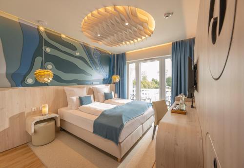 a bedroom with a bed and a painting on the wall at Golf 'n Wave Aktivresort Fehmarn in Fehmarn