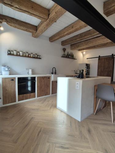 une cuisine avec un réfrigérateur blanc et des placards en bois dans l'établissement La Lanterne, à Saint-Hippolyte