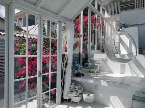 a room with a window with pink flowers at Ample Villa 小希臘民宿 in Ruifang