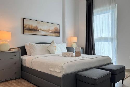 a bedroom with a large bed and a window at Elegant 4BR - Stylish Pearl Edge Escape in Abu Dhabi