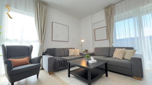 a living room with two couches and a coffee table at Elegant 4BR - Stylish Pearl Edge Escape in Abu Dhabi