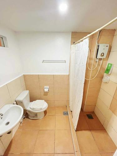 a bathroom with a toilet and a sink at Travelbee Business Inn in Cebu City