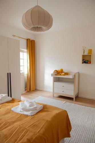 a white room with a bed and a desk at Nestkoje - Ihr Ferienzuhause für Groß & Klein in Neustadt an der Weinstraße
