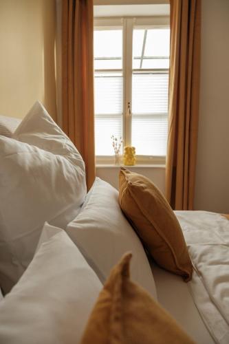 a bed with white pillows and a window at Nestkoje - Ihr Ferienzuhause für Groß & Klein in Neustadt an der Weinstraße