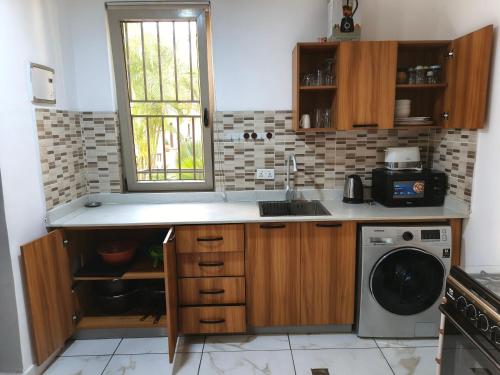 a kitchen with a sink and a washing machine at Accra City Studios & Apartment in Accra