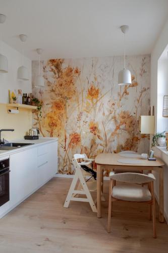 a kitchen with a table and a wall with a painting at Nestkoje - Ihr Ferienzuhause für Groß & Klein in Neustadt an der Weinstraße