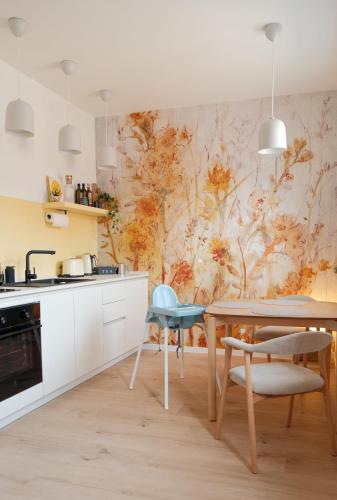 a kitchen with a table and chairs and a wall mural at Nestkoje - Ihr Ferienzuhause für Groß & Klein in Neustadt an der Weinstraße