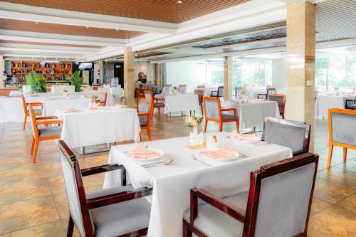 a dining room with white tables and chairs at Swiss Lenana Mount Hotel in Nairobi