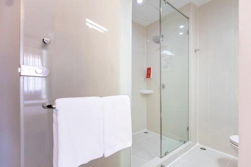 パタヤ・セントラルにあるEasy Planet Pattayaのシャワーとトイレ付きの白いバスルーム
