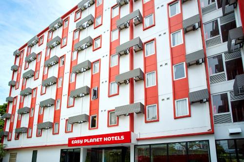 an apartment building with red and white facade at Easy Planet Pattaya in Pattaya