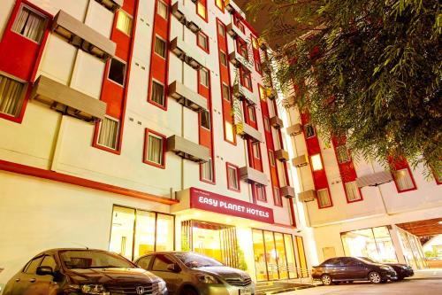 two cars parked in front of a building at Easy Planet Pattaya in Pattaya