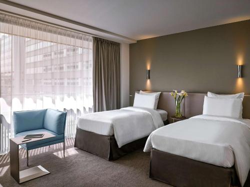 Una cama o camas en una habitación de Pullman Paris Tour Eiffel