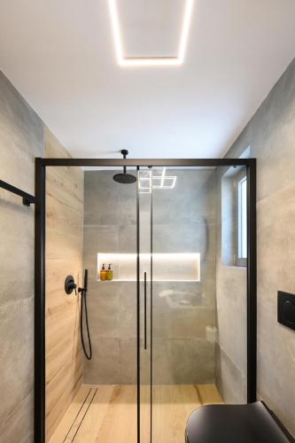 a bathroom with a shower with a glass door at La Casa Del Rio in Kymi