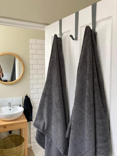 a bathroom with two gray towels hanging on a wall at Studio Room Durban North in Durban