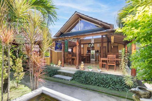 a house with a pond in front of it at Maha Nusa Menjangan in Banyuwedang