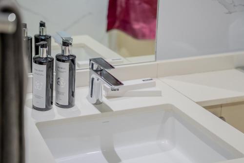 a bathroom sink with two bottles on a counter at 2BR Private Apartment in Al Zahia Sharjah - Wood house in Sharjah