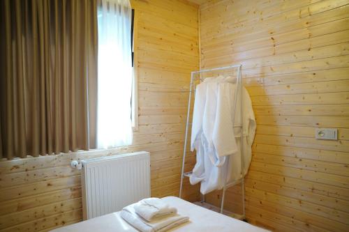 a bathroom with a wooden wall with towels on a rack at your dream cottage in Ts'ikhisdziri