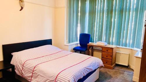 a bedroom with a bed and a chair next to a window at Budget Stay In Luton 02 02 in Luton