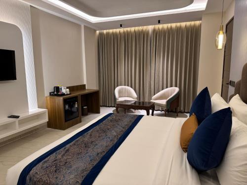 a hotel room with a large bed and a tv at RC Dream Palace in Greater Noida