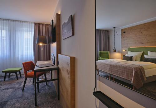 a hotel room with a bed and a desk with a desk at Hotel Restaurant Burg-Klause in Burg auf Fehmarn