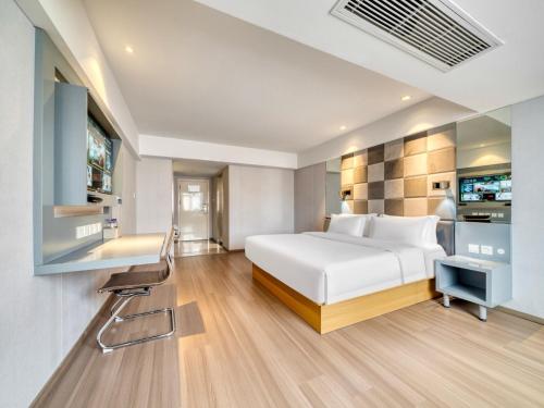 a bedroom with a white bed and a desk at Zsmart智尚酒店杭州浙大紫金港城西银泰店 in Hangzhou