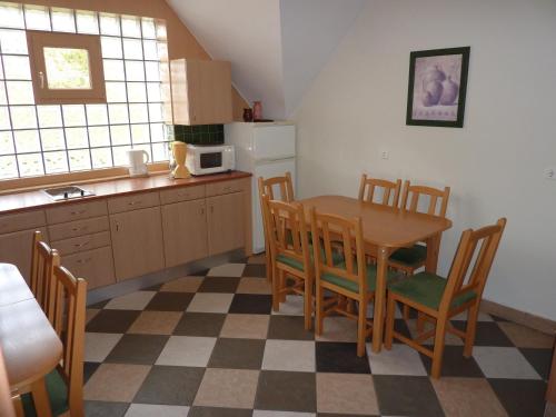 a kitchen with a table and chairs and a refrigerator at Party Panzió Hegykő in Hegykő
