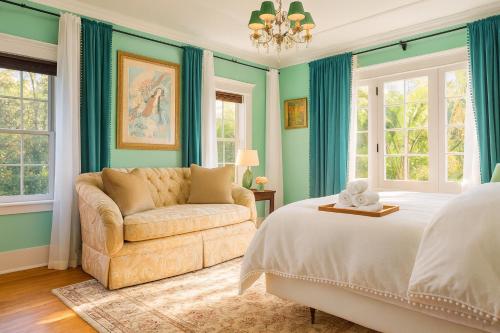 a bedroom with a bed and a couch and windows at Central Hollywood Homestay Getaway in Los Angeles