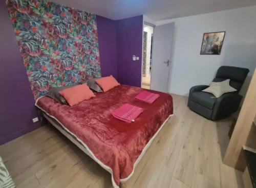 a bedroom with a large bed and a chair at Maison des Ramiers in Saint-Paul