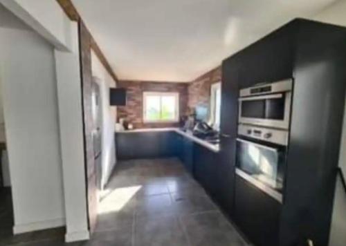 a small kitchen with a stove and a sink at Maison des Ramiers in Saint-Paul