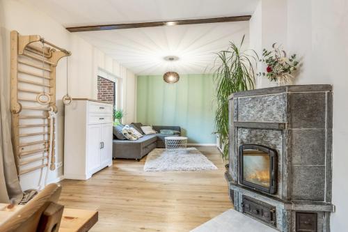 ein Wohnzimmer mit Kamin und Couch in der Unterkunft Gemütliches kleines Haus mit 3-4 Schlafplätzen in Ritterhude