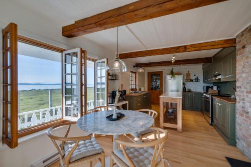 a kitchen and dining room with a table and chairs at Quietude by the River - La dependance sur les battures in Notre-Dame-du-Portage