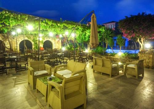 a restaurant with chairs and tables and a patio at night at ANADOL Hotel & Pool Central Kyrenia in Temblos
