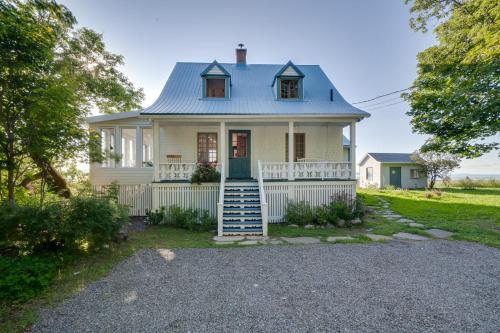 a white house with a blue roof at Quietude by the River - La dependance sur les battures in Notre-Dame-du-Portage
