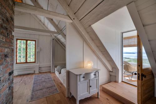 a bedroom in a attic with a bed and a window at Quietude by the River - La dependance sur les battures in Notre-Dame-du-Portage