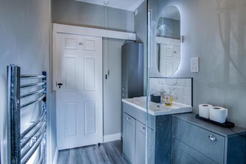 a bathroom with a sink and a mirror at Glenvale - 2 Bedroom Apartment - Saundersfoot in Saundersfoot