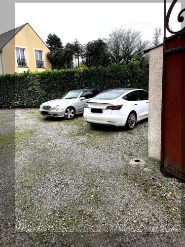 a couple of cars parked in a parking lot at Un jardin au bord de l'eau in Montreuil