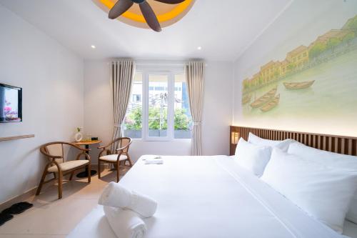 a bedroom with a large white bed and a table at Sujet Residence Service Da Nang in Da Nang