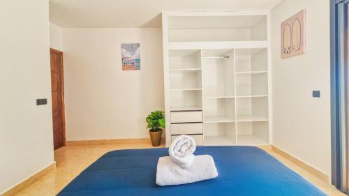 - une chambre avec un lit bleu et des étagères blanches dans l'établissement Surf & Sun Apartment in Imsouane, à Imsouane