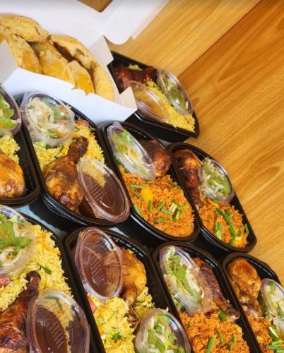a table topped with trays of different types of food at Mckeown Hotel in Kumasi