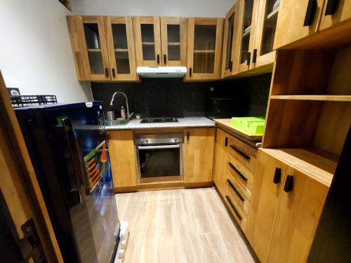 a kitchen with wooden cabinets and a stove top oven at Cotonou Bois Fleuri Suites - Le Loft Naturel A1 in Cotonou