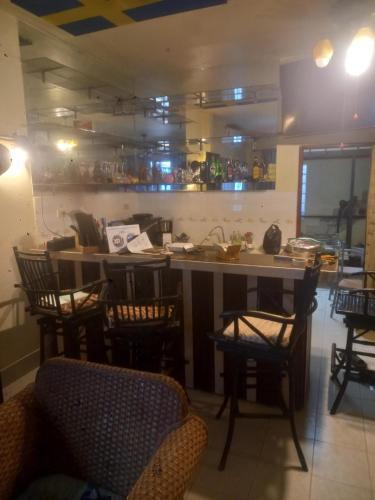 a room with a kitchen with chairs and a counter at Sweden Inn Hostel Chalong in Ban Klang