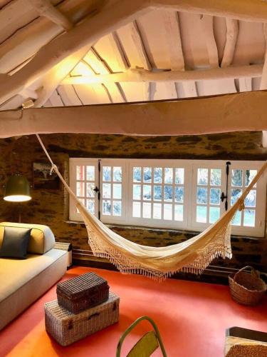 a bedroom with a hammock hanging from the ceiling at The Cliffs - Cala Porto do Val in O Vicedo