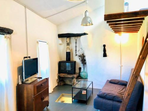 a living room with a tv and a couch at OBarqueiro - El descanso del Peregrino in O Barqueiro