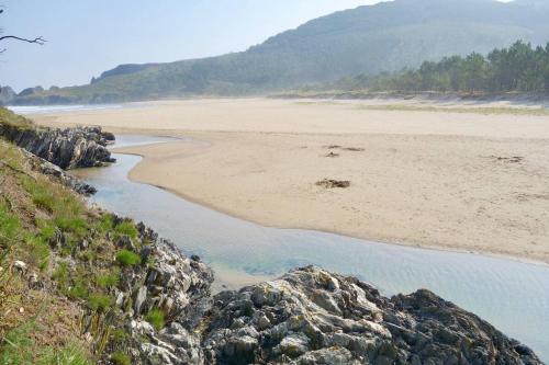 a view of a beach with rocks and water at OBarqueiro - El descanso del Peregrino in O Barqueiro
