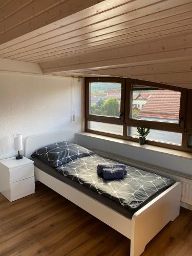 a bed in a small room with two windows at Moderne Monteur- und Ferienwohnung am Plettenberg in Dotternhausen